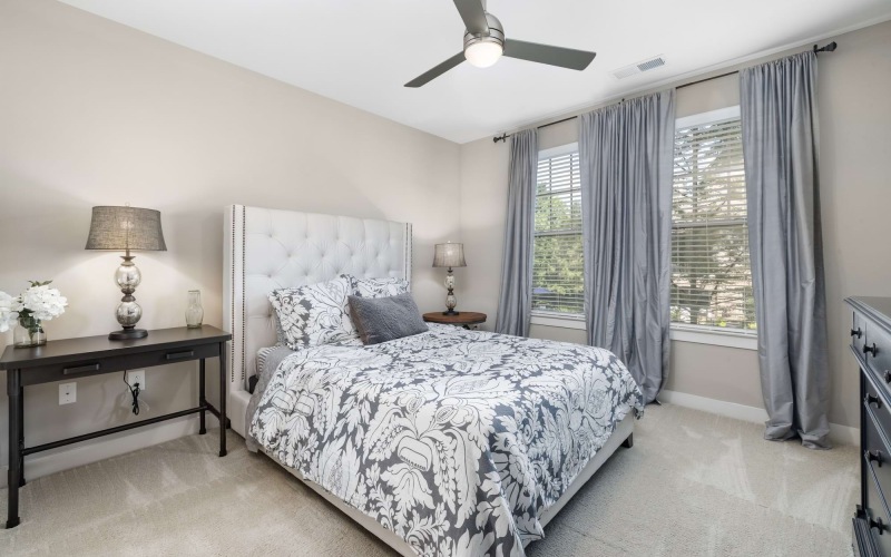 bedroom with large windows and nightstand
